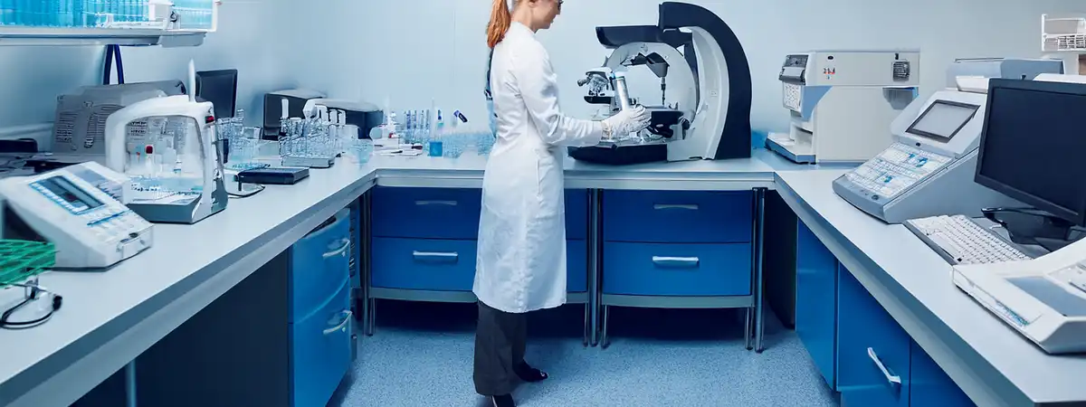 Panorámica de laboratorio de patología: técnico en microtomo y estaciones de tinción